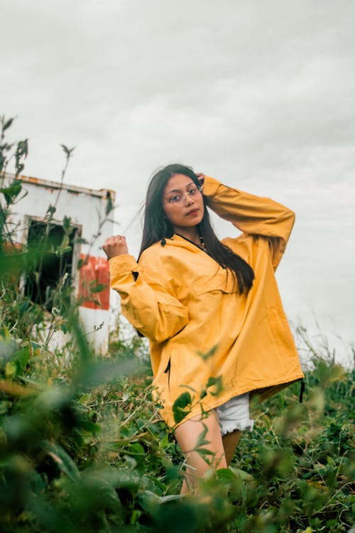 Photographie De Mise Au Point Sélective D'une Femme Debout Portant Un Pull Jaune