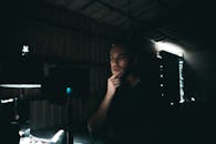 一个人在光线昏暗的工业空间里沉思，思绪万千