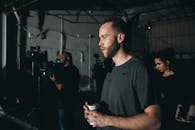 在电影片场，一个男人拿着咖啡杯，坦率而深思熟虑的形象被拍摄下来