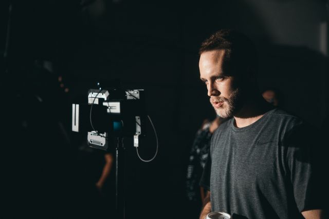 A camera operator working on a dimly lit film set — photo by Kyle Loftus on Pexels