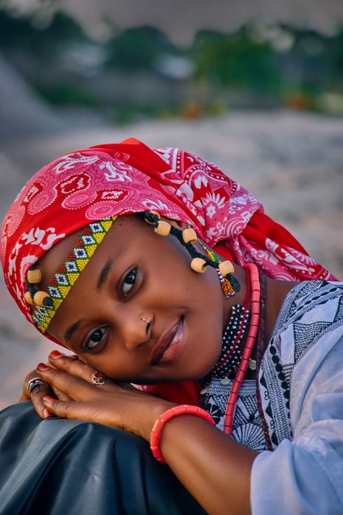 Free Vibrant close-up portrait of a woman in traditional attire with a colorful headscarf, smiling warmly outdoors. Stock Photo