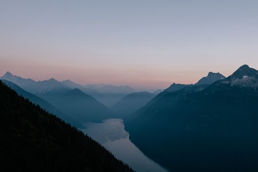 Peaceful mountain view with a winding river at dusk, perfect for nature enthusiasts.