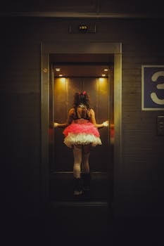 A woman in a tutu and corset inside an elevator, exuding a dramatic, spooky vibe.