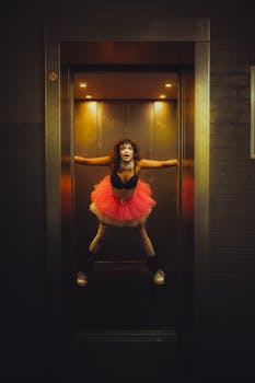 Dramatic portrait of a gothic clown with bold makeup in an elevator, showcasing dark aesthetic and cosplay.