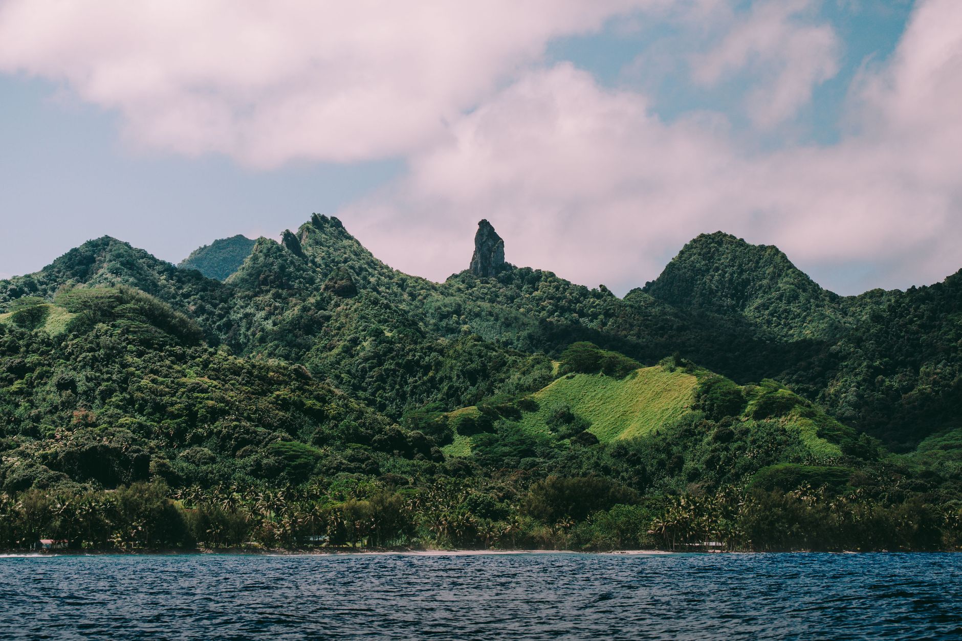 Scenic view of lush mountain range and ocean, perfect for travel and nature themes.