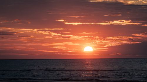 Free Beautiful sunset over ocean with vibrant colors creating a serene atmosphere. Stock Photo