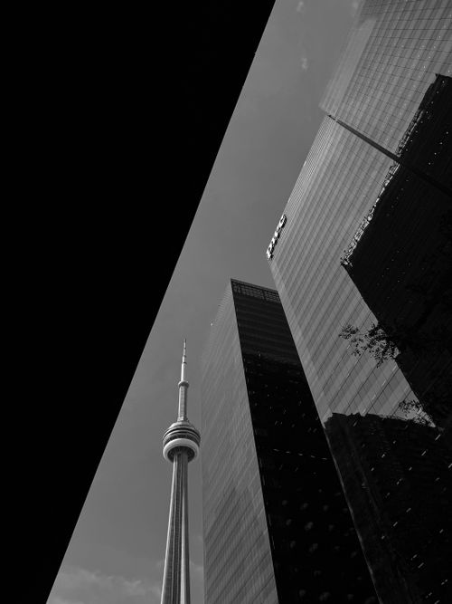 Free Dramatic black and white view of Toronto's CN Tower amid skyscrapers. Stock Photo
