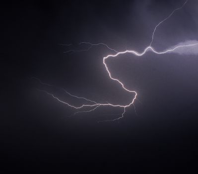 Stunning capture of a lightning bolt illuminating a dark, stormy sky at night.