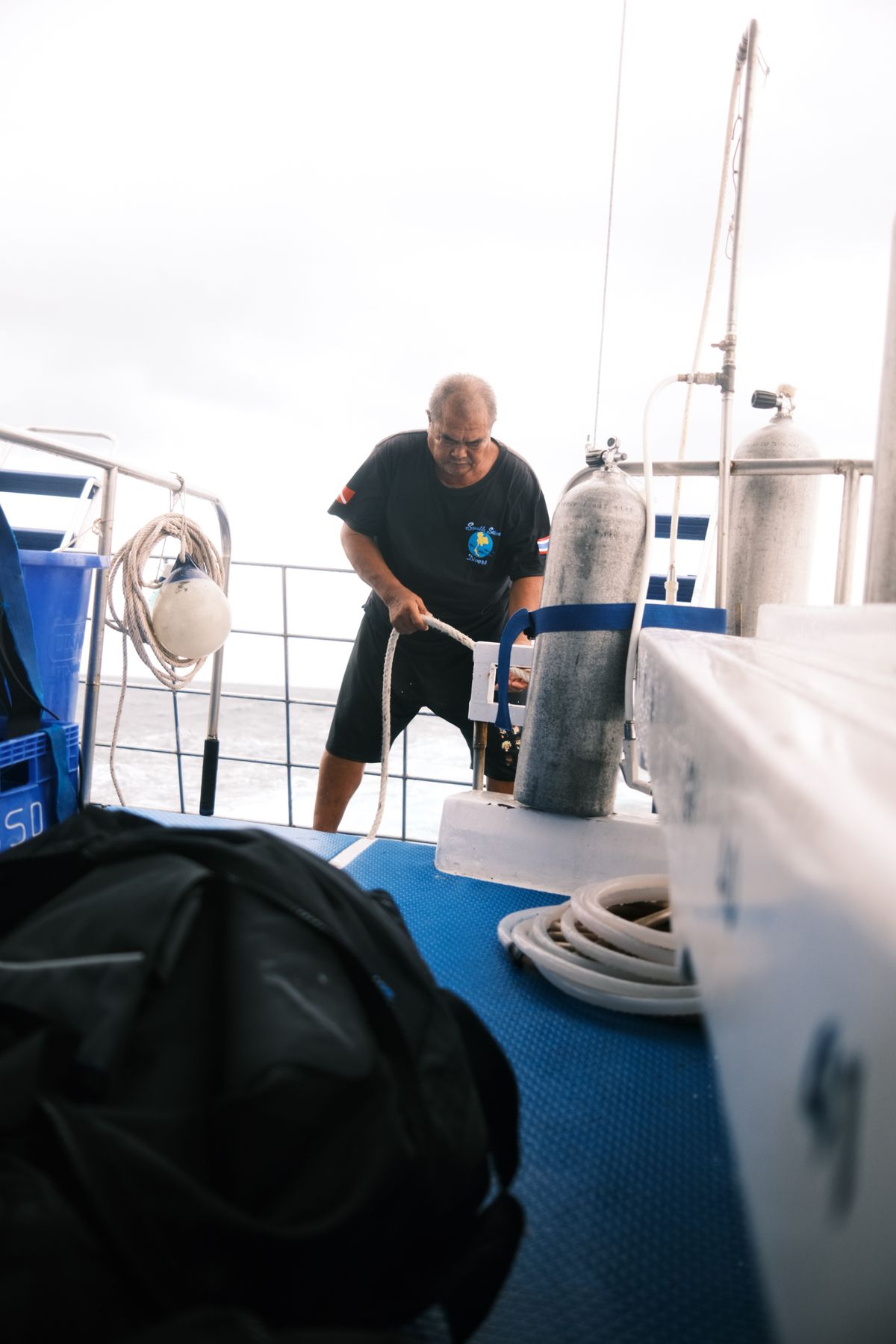 Dive center team preparing tanks and equipment on a boat