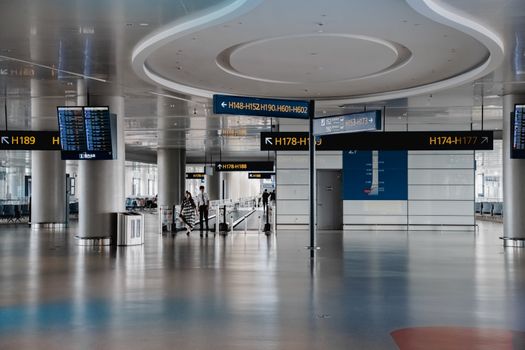 Spacious interior view of a modern airport terminal in Shanghai with signage and travelers.