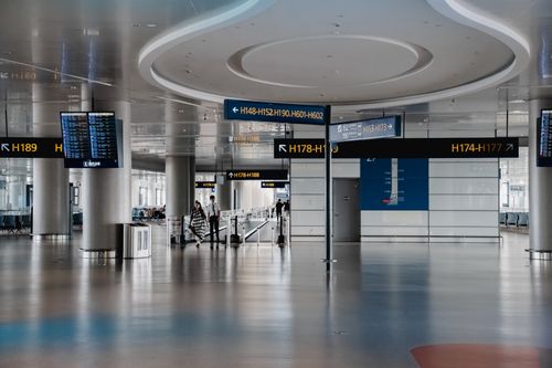 Free Spacious interior view of a modern airport terminal in Shanghai with signage and travelers. Stock Photo