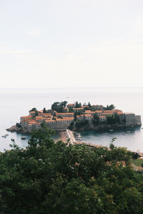 Free Explore the historic beauty of Sveti Stefan island with lush greenery and azure waters. Stock Photo