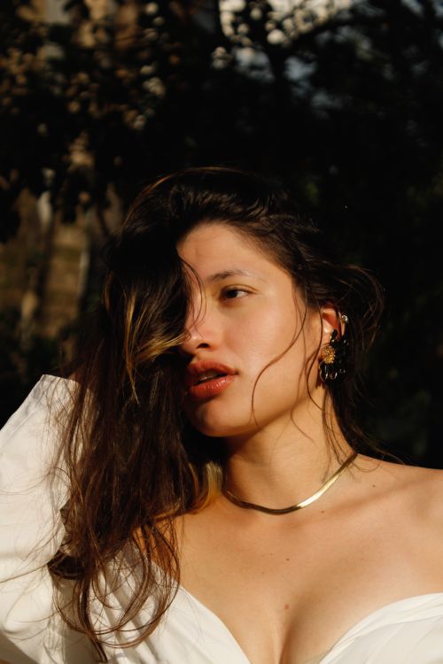 Free A striking portrait of a woman basking in sunlight, showcasing natural beauty and elegance in Brazil. Stock Photo