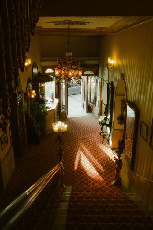 Free Sunlit, vintage hotel lobby in İstanbul with a grand staircase and ornate chandeliers. Stock Photo