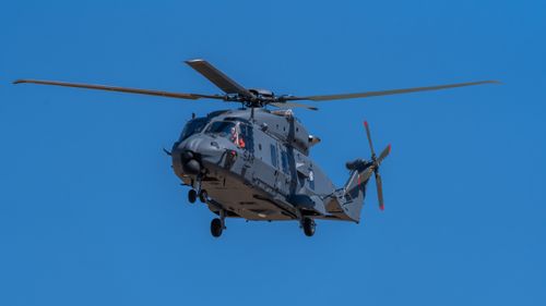 Free An NH90 military helicopter flying against a bright, clear blue sky in Los Llanos, España. Stock Photo