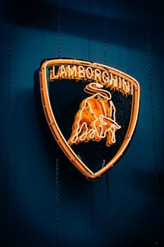 An illuminated Lamborghini logo shines brightly on a dark background, photographed in İzmir, Türkiye.