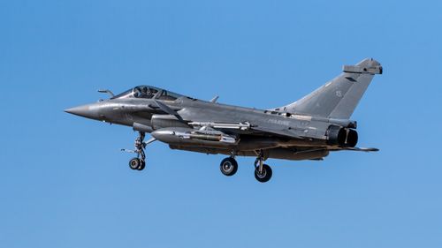 Free A Rafale fighter jet in flight over Los Llanos, Spain, under a clear blue sky. Stock Photo