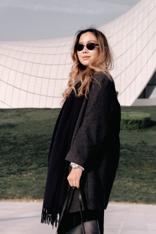 Free Fashionable woman in sunglasses outdoors near modern architectural structure Stock Photo