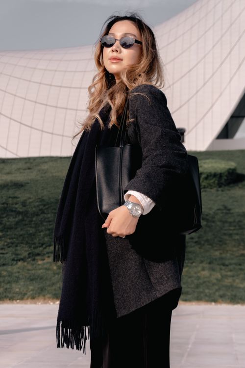 Free Fashionable woman in sunglasses posing confidently against modern backdrop, showcasing urban style. Stock Photo