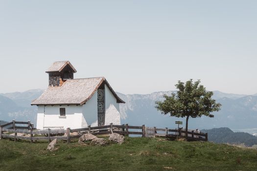 Charming mountain chapel amidst serene alpine landscape in Tirol, Austria, perfect for peaceful retreats.