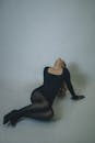 Woman in Black Dress Posing Dramatically on Floor