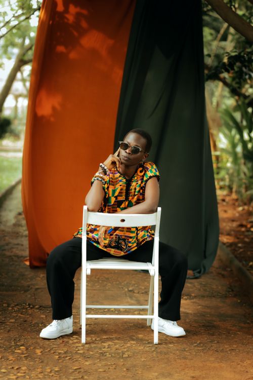 Free Fashionable person sitting outdoors wearing colorful attire, exuding style and confidence. Stock Photo