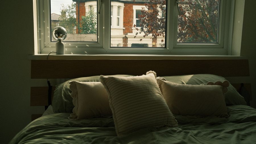 Cozy bedroom with soft bedding and autumn view