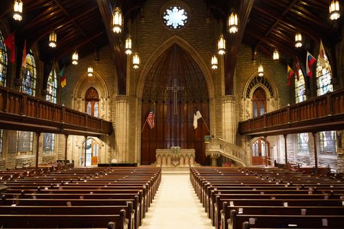 Free A captivating view of a historic Gothic church interior with wooden pews, stained glass windows, and high ceilings. Stock Photo