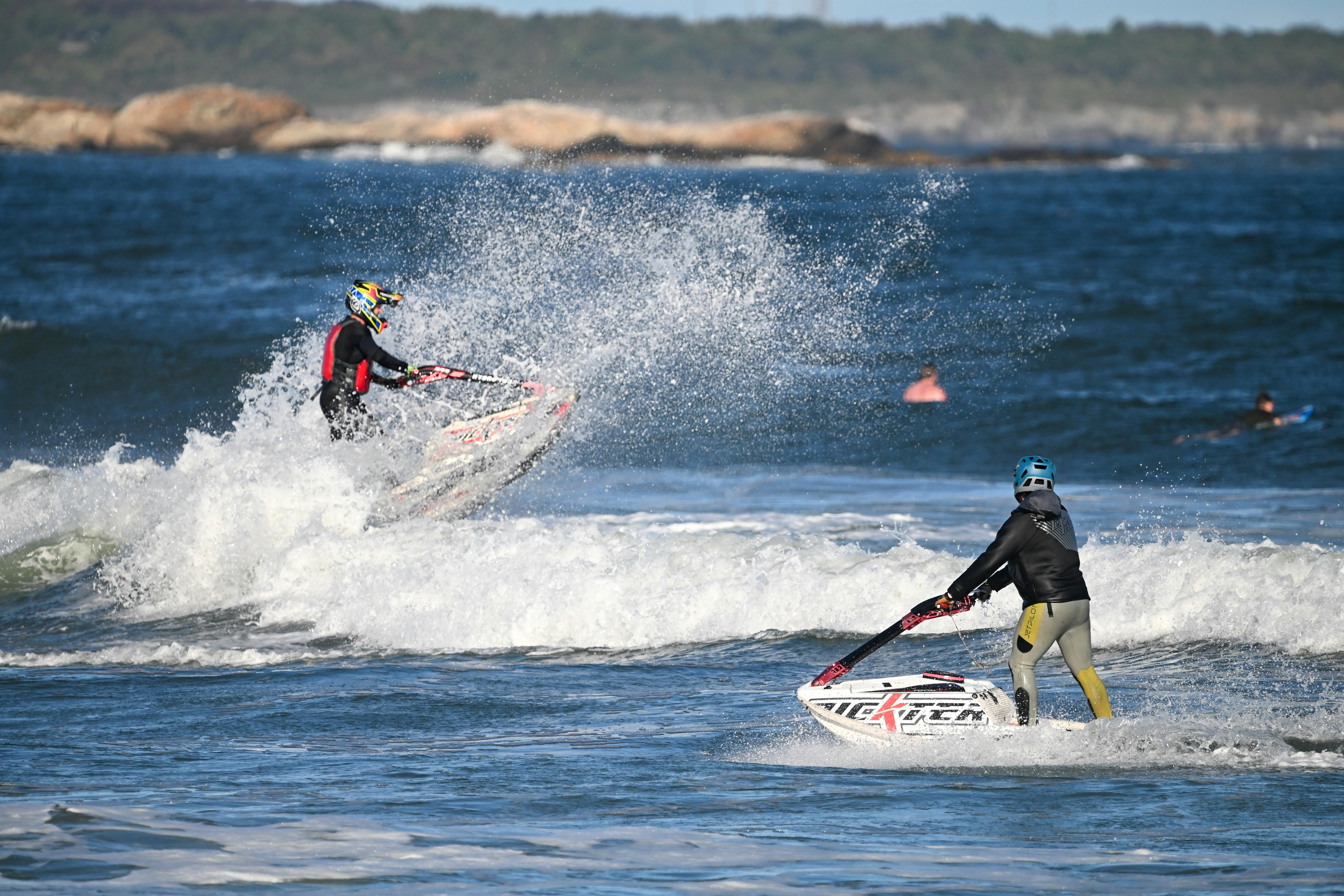 Dynamic jet skiing action with riders navigating waves in Narragansett, Rhode Island.