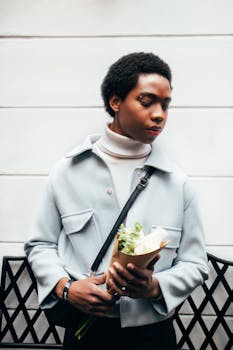 Portrait of a stylish person holding flowers against a modern backdrop in Cuenca, Ecuador.