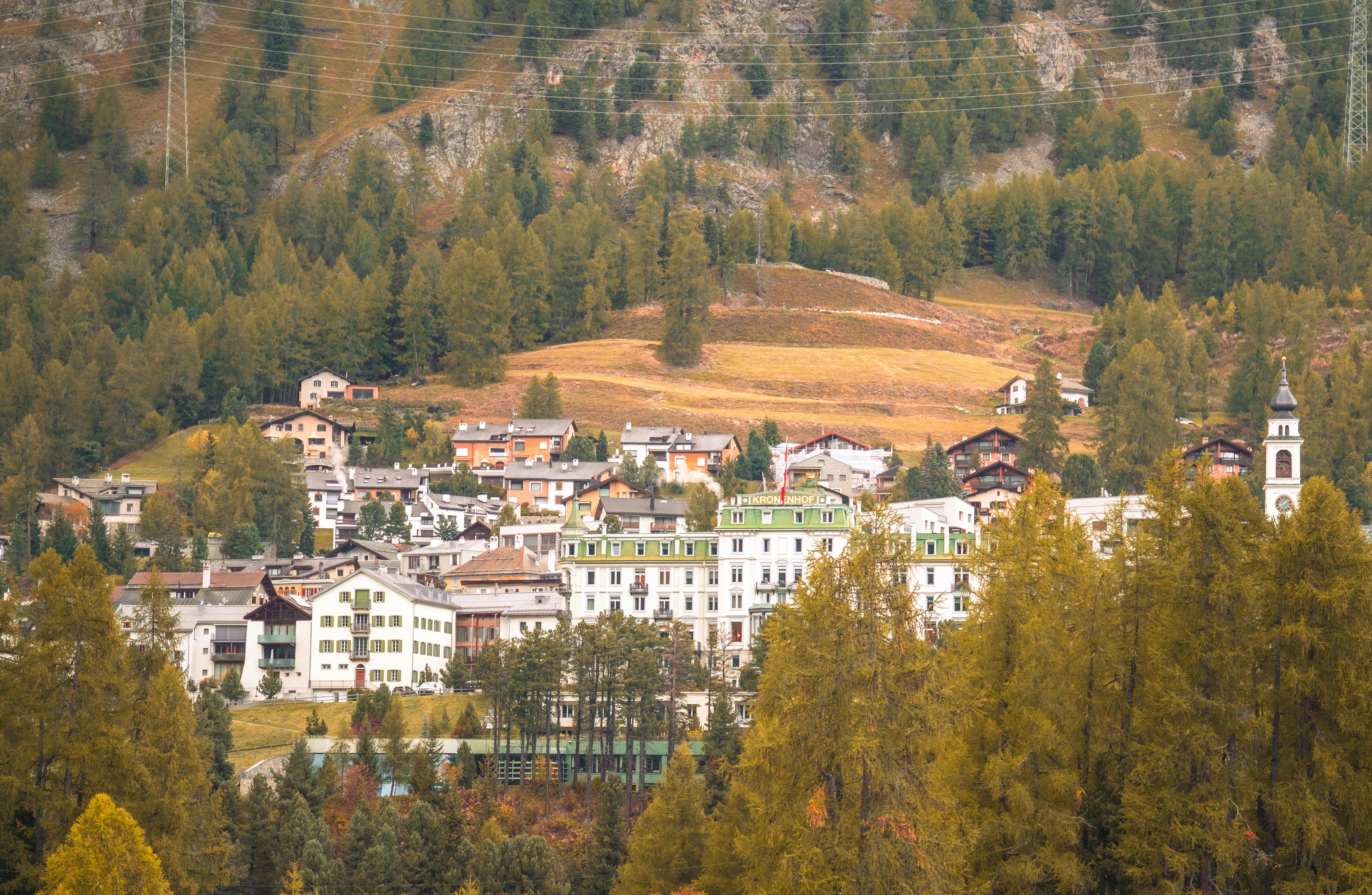 Charming village nestled in the Swiss Alps surrounded by autumn foliage and mountains.