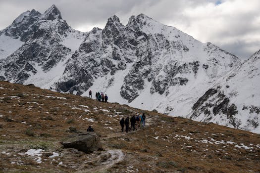 Group of hikers traversing snowy terrain in the Swiss Alps with stunning mountain views.