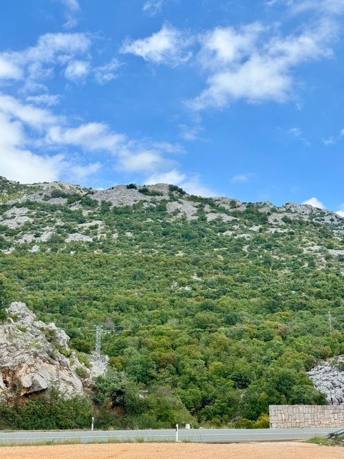 Free Picturesque mountain landscape with rocky terrain and lush greenery under a clear blue sky. Stock Photo