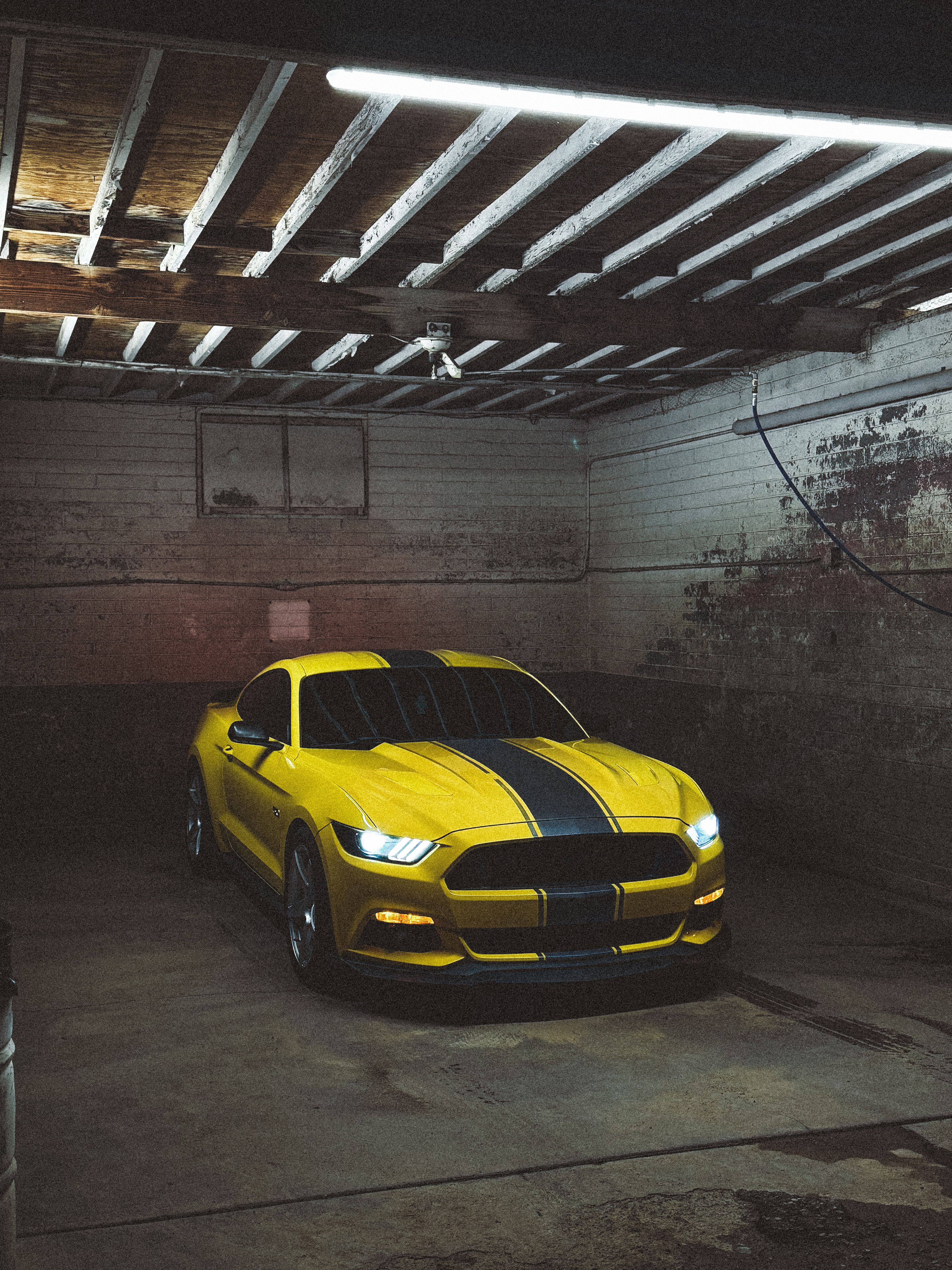 Vibrant Yellow Sports Car in Rustic Garage · Free Stock Photo