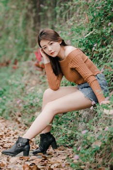 A fashionable woman posing in a natural setting, showcasing autumn style and beauty.