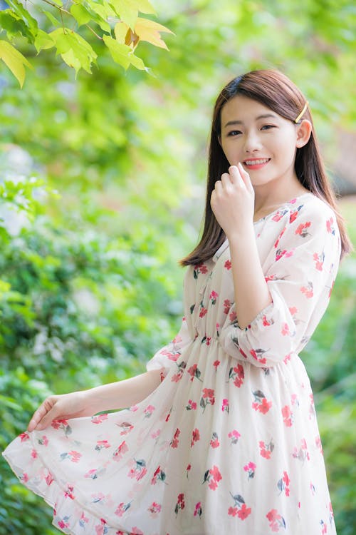 Photo De Mise Au Point Peu Profonde D'une Femme En Robe à Manches Longues à Fleurs Blanche Et Rose