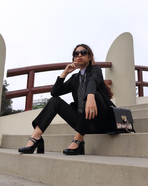 Free Confident businesswoman in stylish formalwear sitting outdoors in a city setting Stock Photo