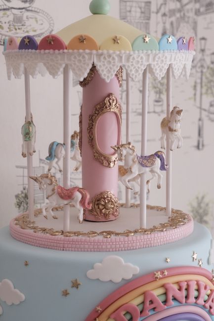 Exquisite carousel cake topper featuring ornate horses and pastel colors.