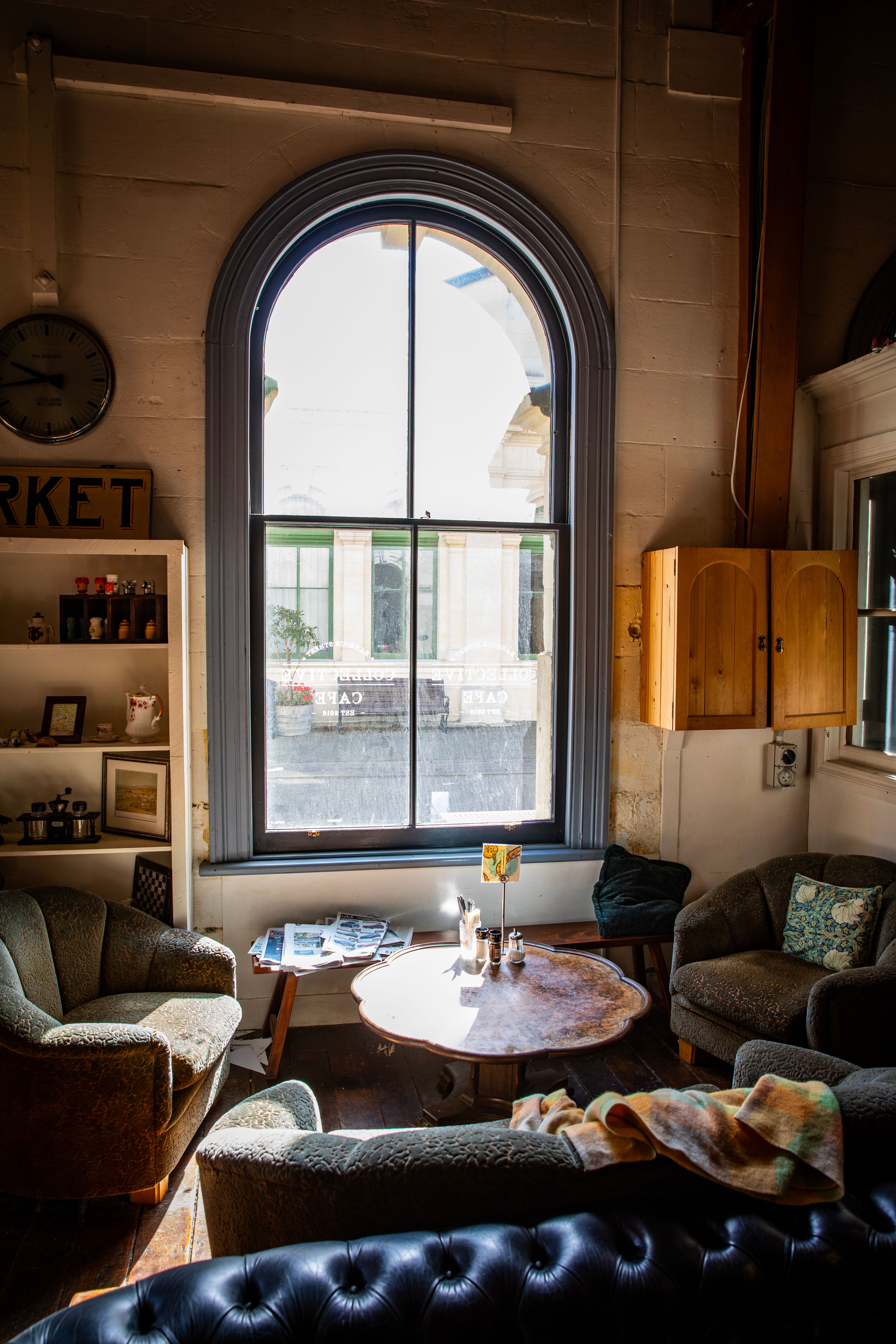 Warm sunlight fills a cozy vintage-style room in Oamaru, New Zealand, highlighting elegant furniture and decor.