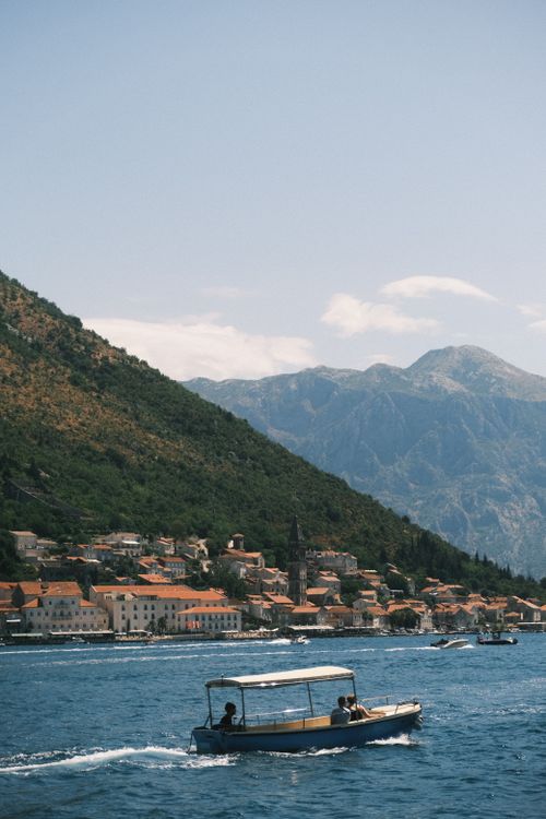 Free Breathtaking view of Perast and Bay of Kotor with a boat cruising through the clear blue waters. Stock Photo