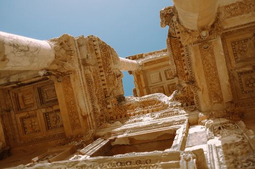 Free Detailed architectural view of ancient Roman ruins under a clear blue sky, showcasing intricate carvings. Stock Photo