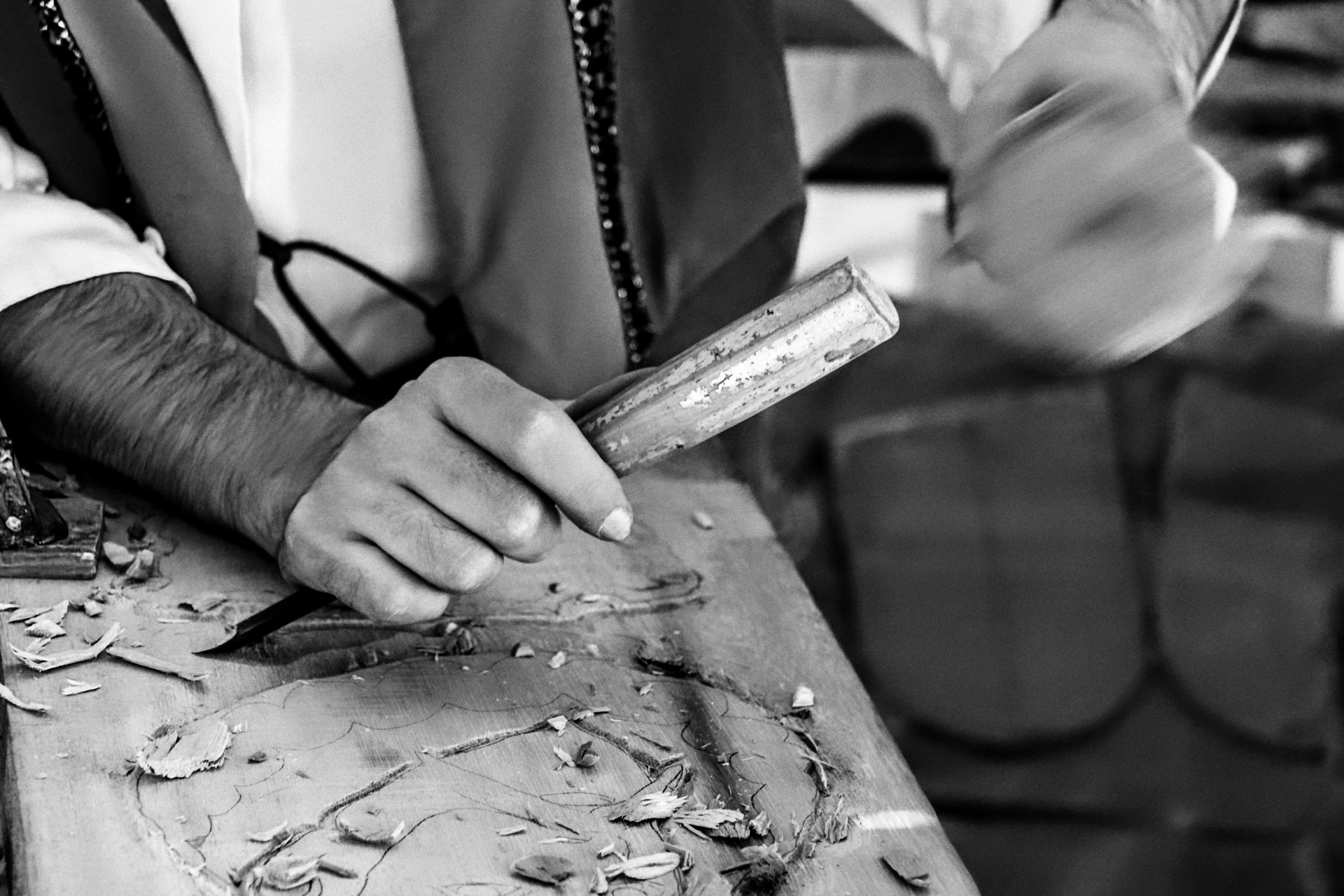 A craftsman skillfully carves wood in a traditional workshop in Alcalá de Henares, Spain. - Alcalá del Júcar