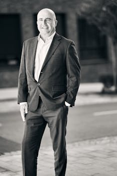 Confident businessman posing outdoors in Bratislava's urban environment.