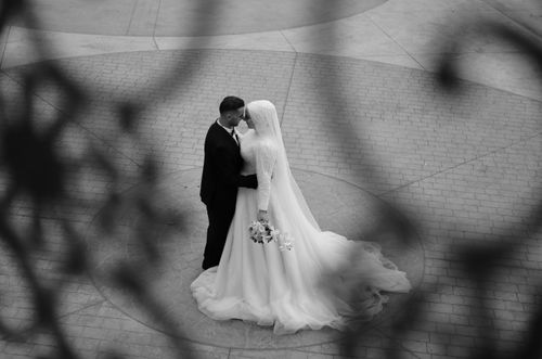 Free A romantic black and white photograph capturing a tender wedding kiss from above. Stock Photo