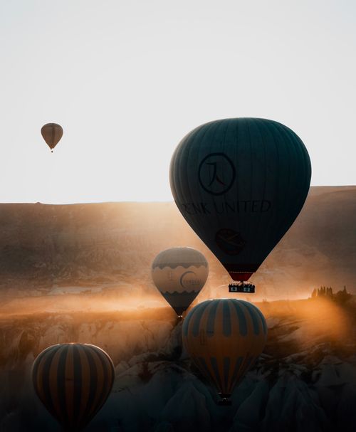 Free Beautiful hot air balloons floating over Cappadocia at sunrise, creating a stunning silhouette. Stock Photo