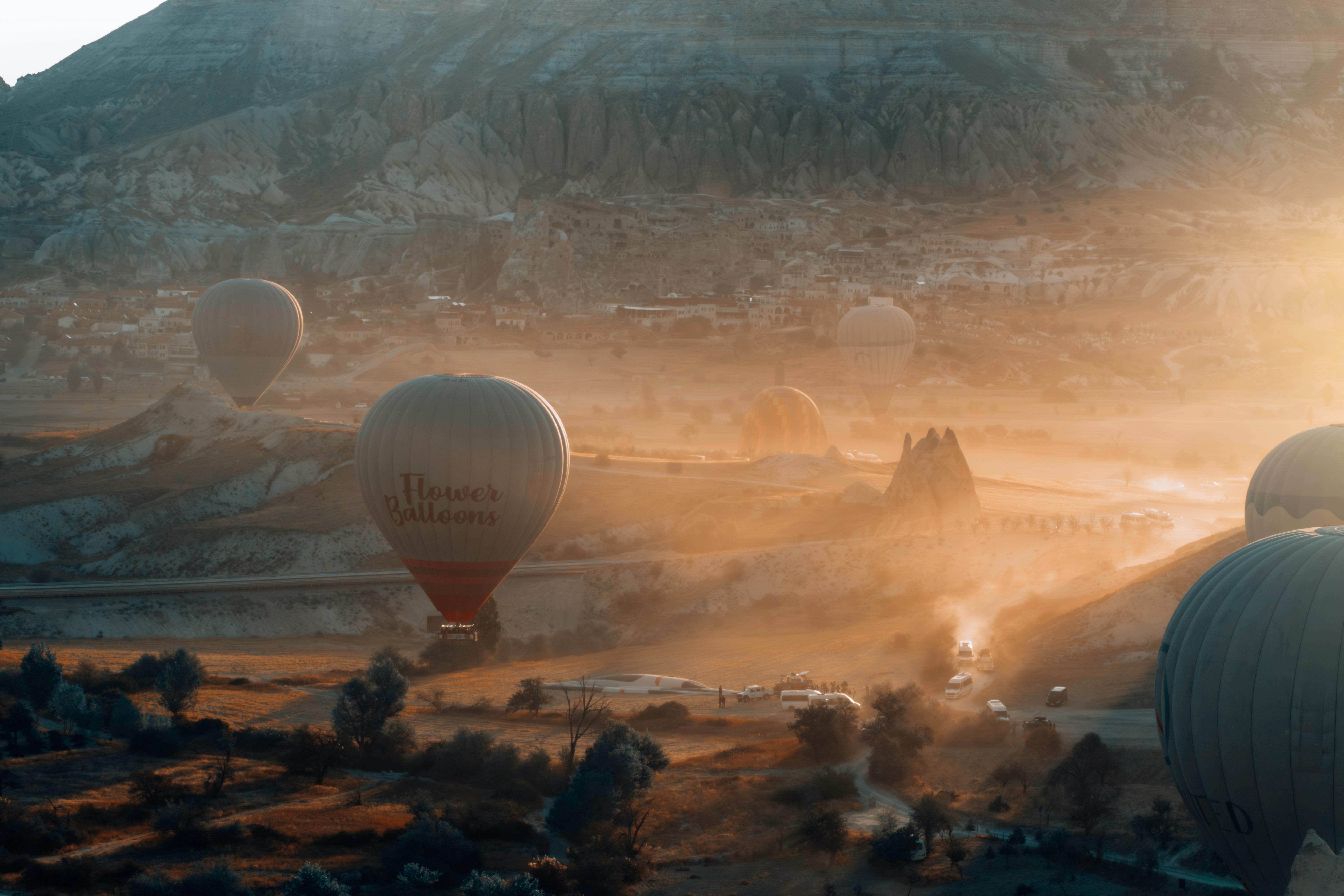 Stunning aerial view of hot air balloons rising over Cappadocia's unique landscape at sunrise.