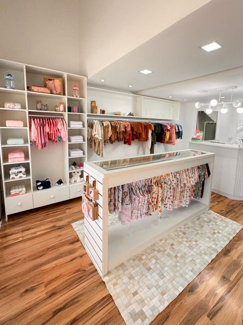 Miljöbild – Charming children's boutique with neatly organized clothes, warm lighting, and inviting ambiance.