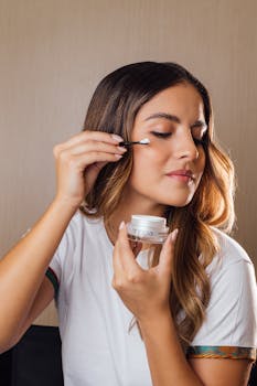 Woman gently applies face cream with a cotton swab, focusing on skincare routine.