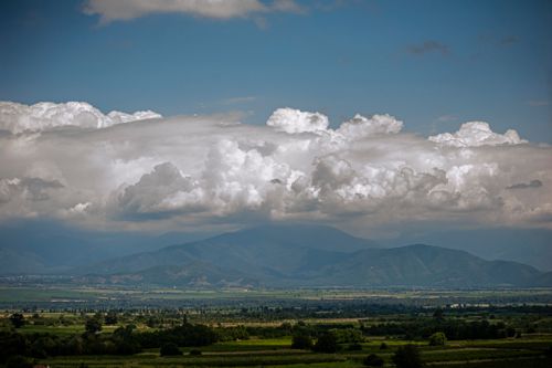 Free Breathtaking view of mountains under expansive clouds and blue sky, perfect for nature lovers. Stock Photo