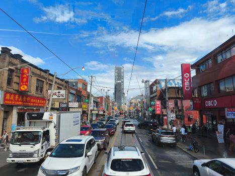 Busy street view in downtown Toronto with high-rise buildings and vibrant shops.